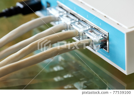 Ethernet cables connected to Desktop Switch or routerboard. Close-up, selective focus 77539100