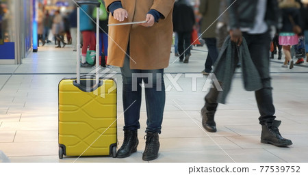 Woman passing time with pad at the airport 77539752