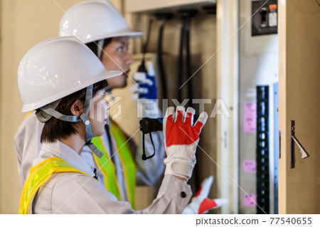 工人在建築工地檢查配電盤 77540655