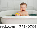 Little happy toddler bathes in a bathtub 77540706
