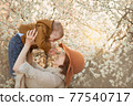 Mom holds the baby against the background of flowering trees 77540717