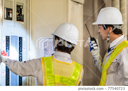 Workers inspecting switchboards at construction sites Workers inspecting switchboards at construction sites 77540723