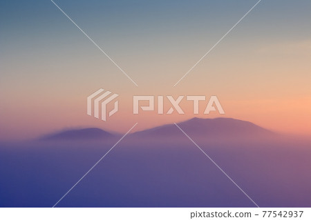 Mountain peaks above the frosty fog. 77542937