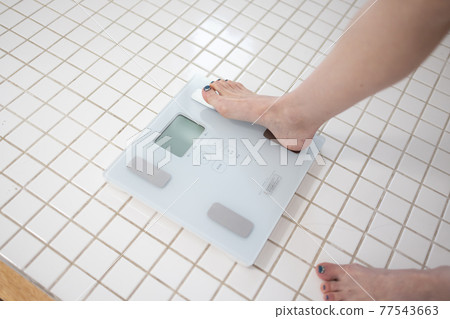 一個女人測量體重 77543663