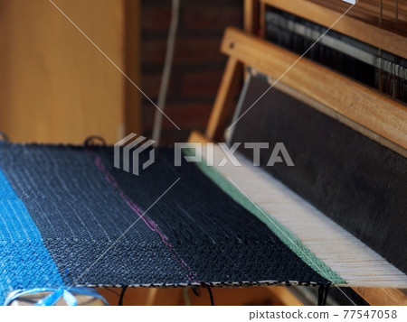 close-up parts of a manual small weaving machine for making education arts and crafts textiles with local traditional materials and yarns in a university's fashion and textiles workshop 77547058