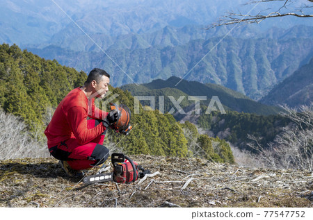 在維護的森林背景下檢查頭盔異常的男性林業工人 77547752