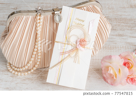 結婚禮包、珍珠項鍊和玫瑰附在派對包上 77547815