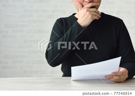 A man who looks at a document and makes a mistake 77548914