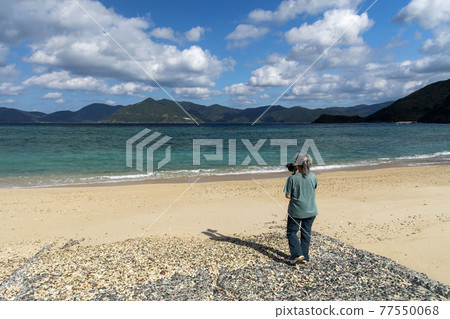 一位女攝影師在奄美群島掛間島的 Saneku 海灘拍攝視頻 77550068