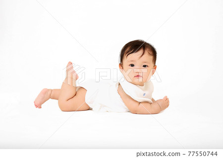 一個女嬰在白色背景上徒步旅行的側視圖。能源、健康、成長、育兒形象 一個女嬰在白色背景上徒步旅行的側視圖。能源、健康、成長、育兒形象 77550744