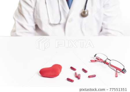 Doctor next to a red heart and pills. Heart checkup. World health day 77551351