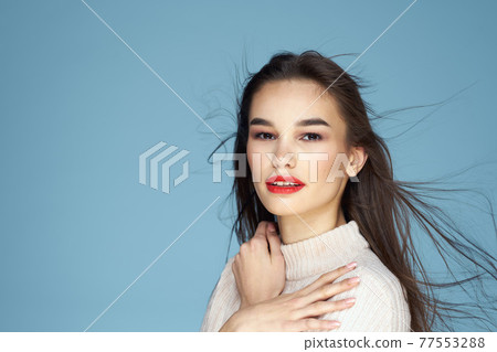 Pretty woman red lips white jacket attractive look close-up blue background 77553288