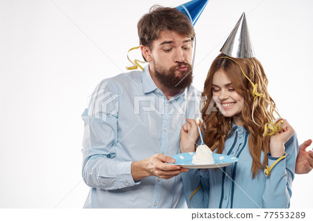 Joyful man and cheerful Woman holiday cake Birthday cap party corporate party young people Joyful man and cheerful Woman holiday cake Birthday cap party corporate party young people 77553289