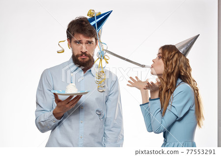 Joyful man and cheerful Woman holiday cake Birthday cap party corporate party young people 77553291