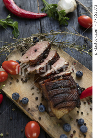 Goose breast Christmas roast with blueberries, tomatoes, red peppers and rosemary served on a wooden board Goose breast Christmas roast with blueberries, tomatoes, red peppers and rosemary served on a wooden board 77553372