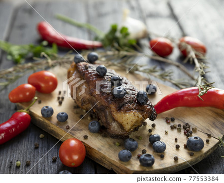 Goose breast Christmas roast with blueberries, tomatoes, red peppers and rosemary served on a wooden board Goose breast Christmas roast with blueberries, tomatoes, red peppers and rosemary served on a wooden board 77553384