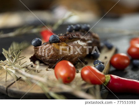 Goose breast Christmas roast with blueberries, tomatoes, red peppers and rosemary served on a wooden board Goose breast Christmas roast with blueberries, tomatoes, red peppers and rosemary served on a wooden board 77553393