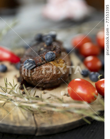 Goose breast Christmas roast with blueberries, tomatoes, red peppers and rosemary served on a wooden board Goose breast Christmas roast with blueberries, tomatoes, red peppers and rosemary served on a wooden board 77553395