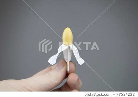 Vaginal or rectal candle in hands on a light background. The drug is in the form of suppositories. The concept of treatment of gynecological diseases and diseases of the rectum 77554228