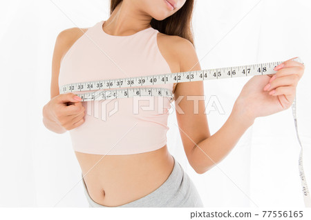 Woman measuring bust with a measure Woman measuring bust with a measure 77556165