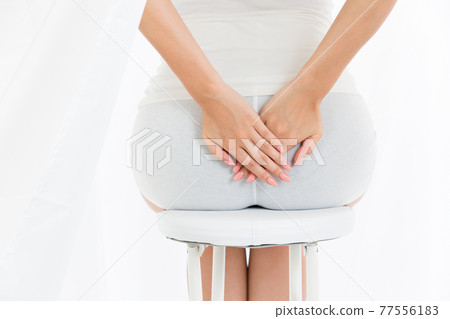 Woman holding her butt Woman holding her butt 77556183