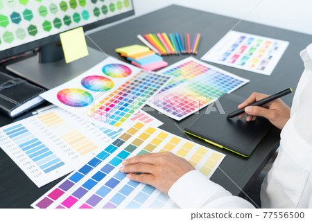 creative graphic designer choosing color scale for editing artwork while working in office. creative graphic designer choosing color scale for editing artwork while working in office. 77556500