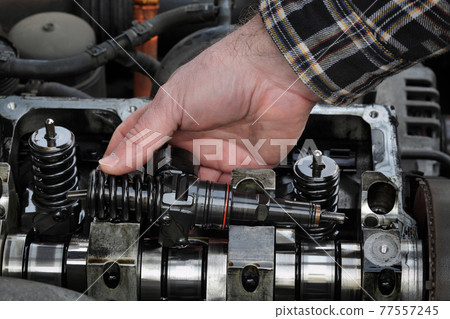 Car mechanic repair injectors of modern diesel engine 77557245