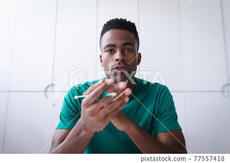 African american businessman sitting in office having video call and making notes 77557418