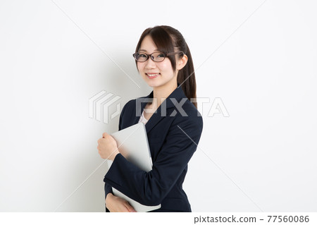 Business woman holding a personal computer Business woman holding a personal computer 77560086