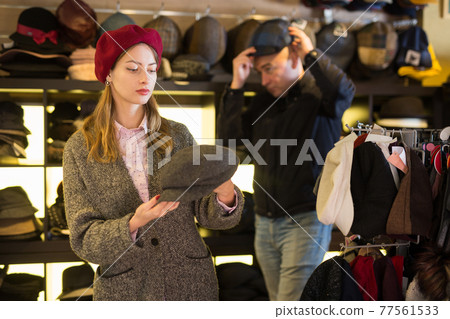 Customers choosing new hats in shop Customers choosing new hats in shop 77561533