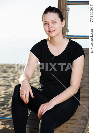 Smiling adult woman is resting after stretching 77561567