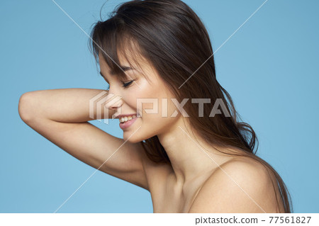 pretty brunette naked shoulders long hair skin care blue background 77561827