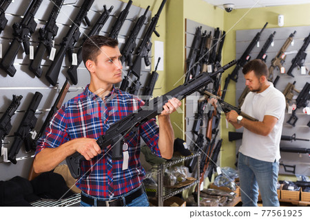 Friends choosing air-powered gun Friends choosing air-powered gun 77561925