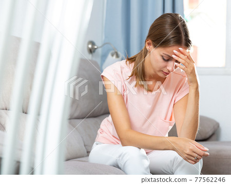 Sick female holding hands on her head Sick female holding hands on her head 77562246