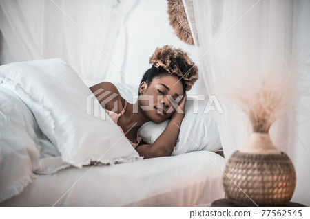 Dark skinned woman sleeping in bedroom Dark skinned woman sleeping in bedroom 77562545