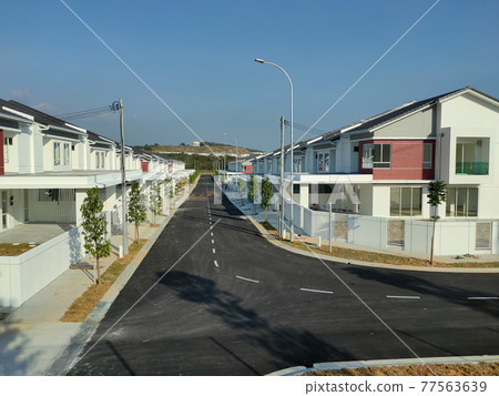 SEREMBAN, MALAYSIA -APRIL 20, 2021: New double story luxury terrace house in Malaysia. Construction almost completed. Designed by an architect with a modern and contemporary style. SEREMBAN, MALAYSIA -APRIL 20, 2021: New double story luxury terrace house in Malaysia. Construction almost completed. Designed by an architect with a modern and contemporary style. 77563639
