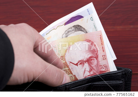Old banknotes from Israel in a black wallet 77565162