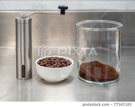 Roasted coffee beans, grinded bean in glass jug and manual grinder Roasted coffee beans, grinded bean in glass jug and manual grinder 77565165