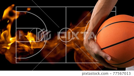 Composition of midsection of basketball player holding basketball over basketball court and flames Composition of midsection of basketball player holding basketball over basketball court and flames 77567013