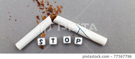 broken cigarette with the word stop on gray background close. stop smoking concept. banner 77567796