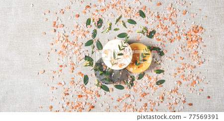 The round handmade soaps and salt with the eucalyptus on the cotton background. 77569391
