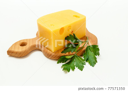 Cheese and parsley on wooden cutting board on white background 77571350