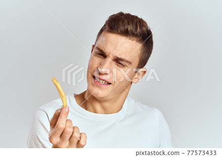 emotional man holding fries calories fast food light background white t-shirt cropped view emotional man holding fries calories fast food light background white t-shirt cropped view 77573433