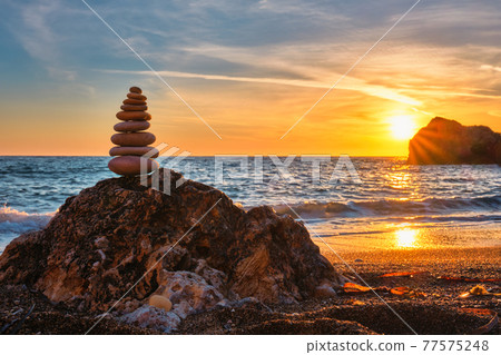 Concept of balance and harmony - stone stack on the beach 77575248
