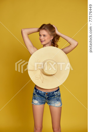 beautiful young blonde woman in shorts with straw hat beautiful young blonde woman in shorts with straw hat 77576449