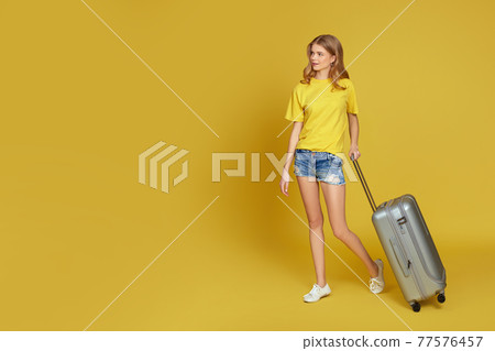 young blonde woman in shorts with gray suitcase young blonde woman in shorts with gray suitcase 77576457