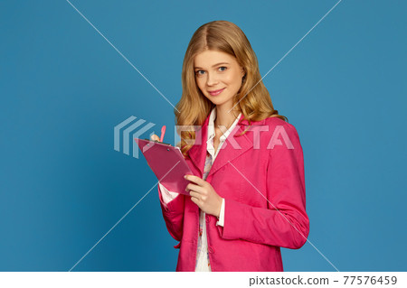 blonde business woman in jacket holding clipboard blonde business woman in jacket holding clipboard 77576459