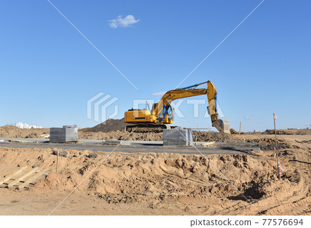 Excavator on earthmoving at construction site. Excavator on earthmoving at construction site. 77576694