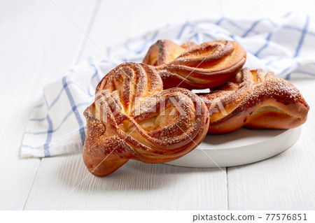 Sweet swirling buns sprinkled with sugar. 77576851