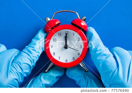 Medical doctor with an alarm clock in her hand. Health care concept Medical doctor with an alarm clock in her hand. Health care concept 77576890